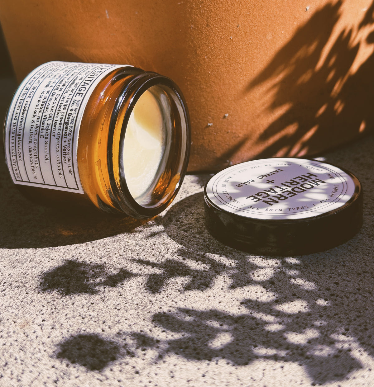 Open jar of Modern Heritage tattoo balm with its lid alongside
